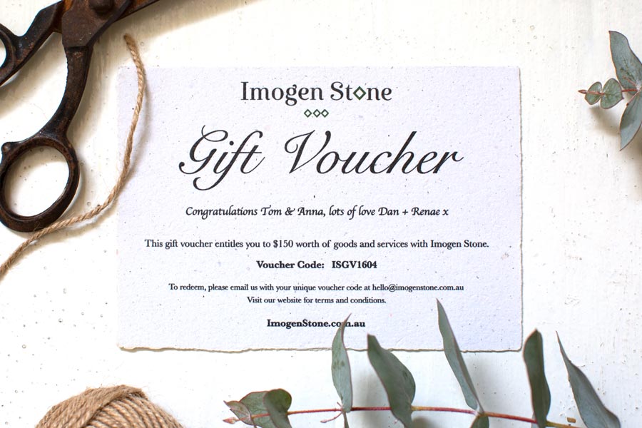 Imogen Stone gift voucher printed on handmade paper, styled on a table with scissors