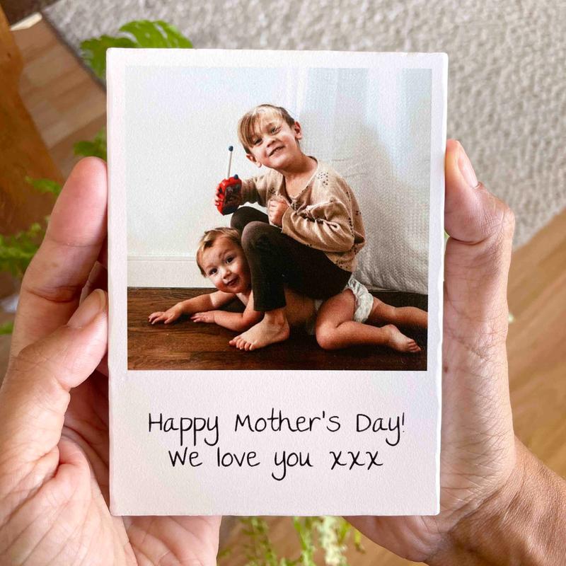 Playful photo of two young brothers printed on a handcrafted Polaroid stone tile – held in loving hands