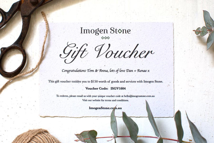 Imogen Stone gift voucher printed on handmade paper, styled on a table with scissors