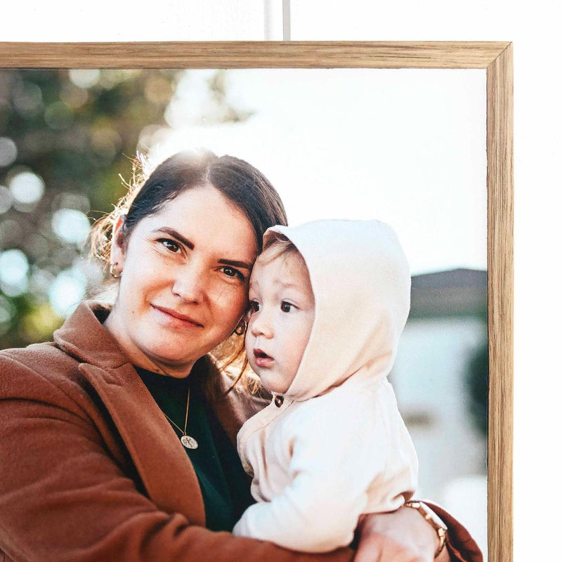 Woman holding a baby photo printed on a Tasmanian oak framed stone panel – handcrafted by Imogen Stone